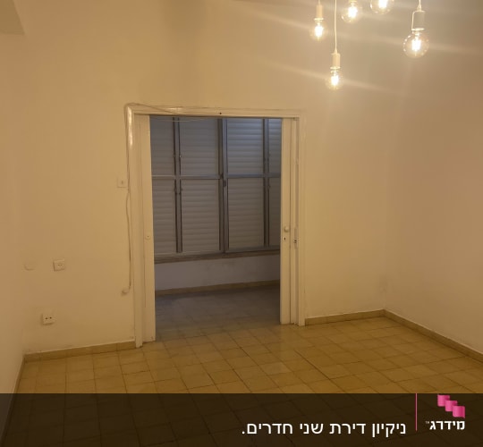חדר ריק עם רצפה נקייה ותאורה תלויה